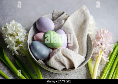Spring table setting with hyacinth flowers and colored eggs on grey concrete table for festive dinner Stock Photo