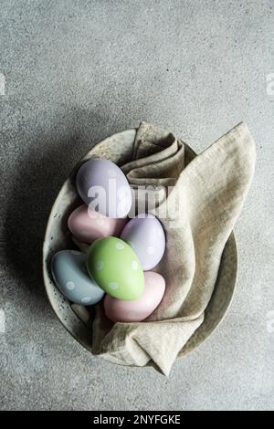 From above gray concrete table setting with colored eggs on ceramic bowl for festive dinner Stock Photo