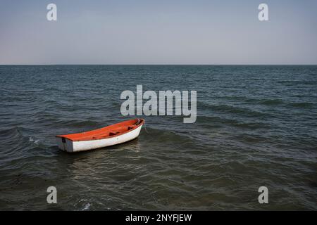 Bright boat floating on rippling sea water on sunny day in nature against cloudless sky in Mauritania Stock Photo