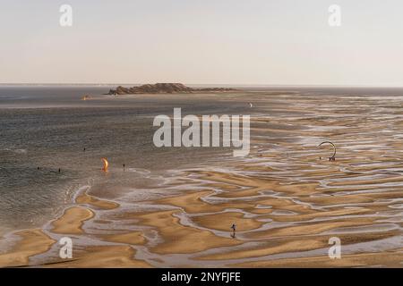 Aerial view of paragliders flying over sandy beach near sea against sky on sunny day in Sahara Mauritania Stock Photo