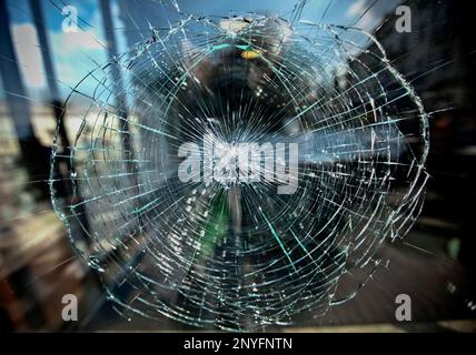 Window with damage effect as net of circles and lines of cracks on translucent glass surface Stock Photo