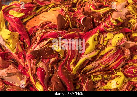 Closeup of vivid red and yellow thick wavy lines poured randomly on surface and spraying small drops Stock Photo