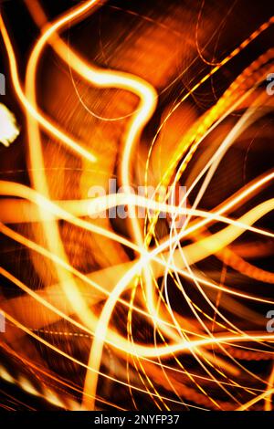 Close-up shot of†bright lines of†orange light flashes sparkling on black background Stock Photo