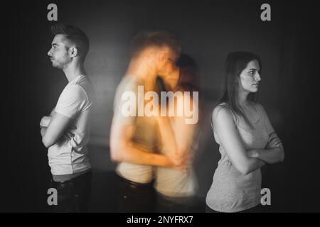 Silhouette of blurred kissing couple between offended man and woman Stock Photo