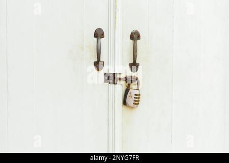 Closed padlock hangs on the white doors. Stock Photo