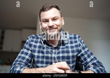 Man sitting desk smiling in web camera while video calling. Stock Photo