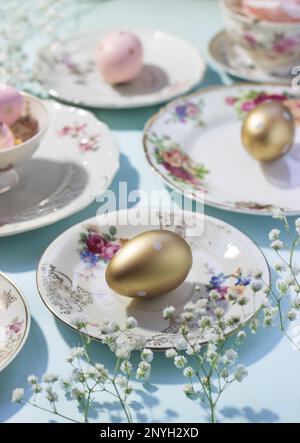 Aesthetic Easter composition made of colorful plates and golden eggs; Easter concept Stock Photo