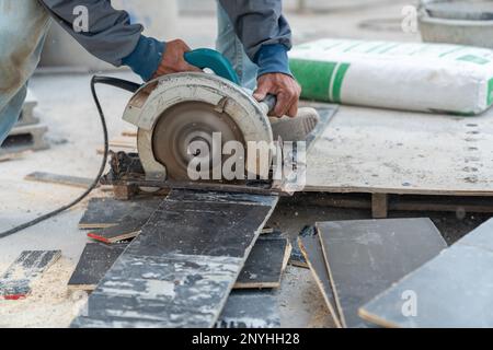 Worker use circular saw cutting plywood for make formwork pour cement.Construction site. Stock Photo