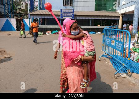 A woman carries her child suffering from Acute Respiratory Infection (ARI) while waiting for treatment at Dr. B C Roy Post Graduate Institute of Pediatric Sciences in Kolkata. People seek treatment in Dr. B C Roy Post Graduate Institue of Pediatric Sciences for their children who experience Acute Respiratory Infection (ARI) with flu-like symptoms such as fever, cold, cough, breathing problems, and fatigue. Hence, more than ten children died due to Acute Respiratory Infection (ARI) in the past few days. Meanwhile, according to local media reports, there is a sudden spike in Adenovirus cases whi Stock Photo