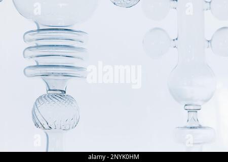 Abstract glass installation, fragments of transparent empty glasses over light blue wall Stock Photo