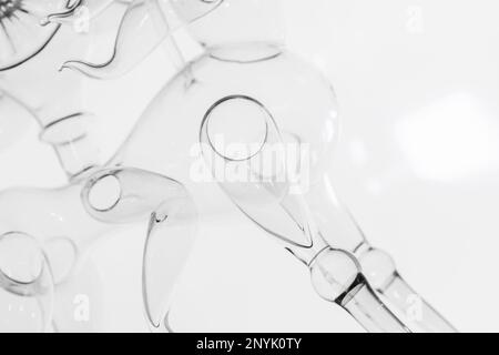 Abstract thin glass installation, fragment of transparent decoration over white wall background Stock Photo