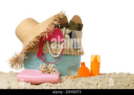Stylish bag with beach accessories on sand against white background Stock Photo