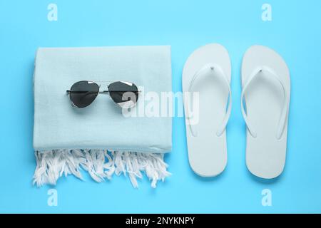 Flat lay composition with different beach objects on light blue background Stock Photo