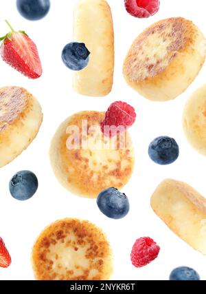 Delicious cottage cheese pancakes and berries falling on white background Stock Photo