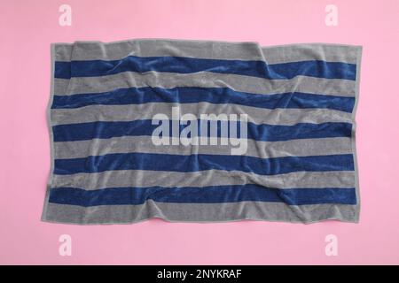 Crumpled striped beach towel on pink background, top view Stock Photo