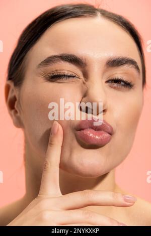 pouting lips c close up of young and brunette woman pouting lips isolated on pink,stock  image Stock Photo