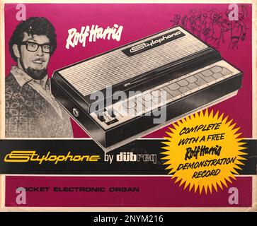 The Stylophone was a huge deal when it launched in 1967, and was the first example of a printed circuit or electronic keyboard most people came across.  It was always intended to be a fun novelty toy although a few musicians also took it up (including The Small Faces).  Production closed in 1975 but it was relaunched in soo7, since when it has been developed using modern circuitry into a number of variations, and even a David Bowie limited edition.  This is one of the very early boxes which housed the all white plastic Treble version. Rolf Harris was the face and sound of the instrument. Stock Photo