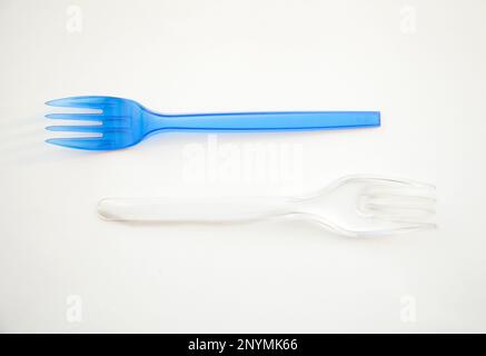 2 forks blue and transparent isolated on white. Plastic cutlery. Beautiful harmony food Yin Yang simple minimalism Stock Photo