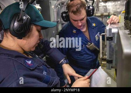 230117-N-HG846-1078 SOUTH CHINA SEA (January 17, 2023) – Engineman 2nd Class Melody White, left, from Los Angeles, and Machinist Mate 1st Class Terry McMurry, right, from Port Jervis, New York, conduct a training evolution in an engine room main space aboard Independence-variant littoral combat ship USS Charleston (LCS 18). Charleston, part of Destroyer Squadron Seven, is on a rotational deployment, operating in the U.S. 7th Fleet area of operations to enhance interoperability with partners and serve as a ready-response force in support of a free and open Indo-Pacific region. Stock Photo