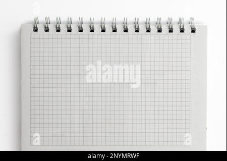 Close-up of a notebook with checkered pages. Spiral notebook isolated Stock Photo