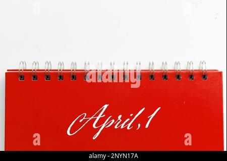 Red notebook with text APRIL 1 on white background. Fool's day celebration concept Stock Photo