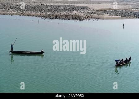 tourists sailing on a wooden boat through river water Stock Photo