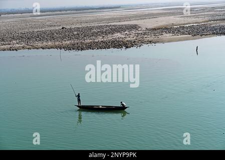 tourists sailing on a wooden boat through river water Stock Photo