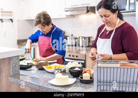 Granny and her daughter cooking together in the kitchen Stock Photo