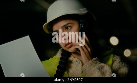 Arabian woman technical engineer female architect businesswoman contractor inspector chief in uniform helmet talk mobile phone discuss business Stock Photo