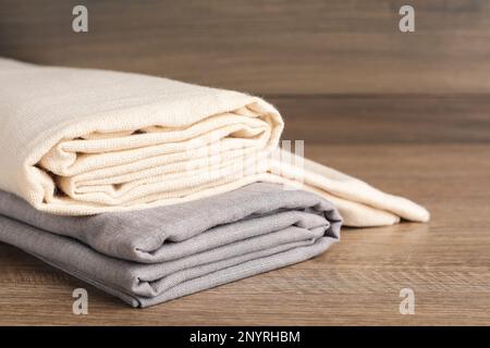 Folded hemp cloths on wooden table, closeup. Space for text Stock Photo