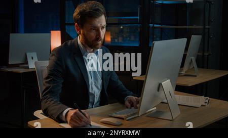 Middle-aged worker adult 40s Caucasian man teacher male executive manage business tasks write notes paper invoice signing document insurance writing Stock Photo