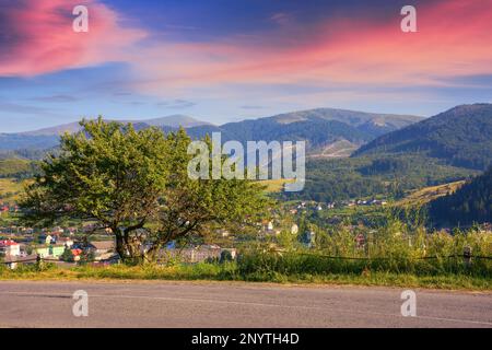 as the sun sets, the road leads through a beautiful countryside. journey continues promising a beautiful scene at every turn Stock Photo