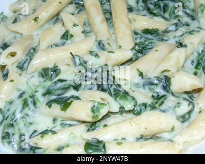 Penne pasta with gorgonzola and spinach in a creamy cheese sauce Stock Photo