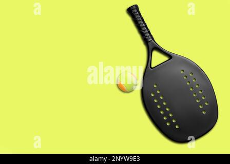 Black professional beach tennis racket and ball on yellow background. Horizontal sport theme poster, greeting cards, headers, website and app Stock Photo