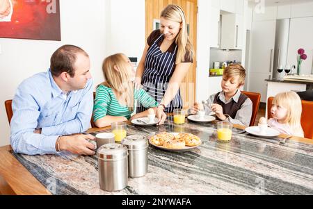 Family Life, Breakfast is Served. A young mother serving her family their morning meal. From a series of related images. Stock Photo