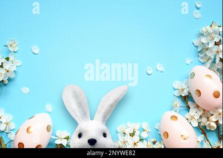 Easter eggs with spring blossom flowers on blue background. Colored Egg Holiday border Stock Photo