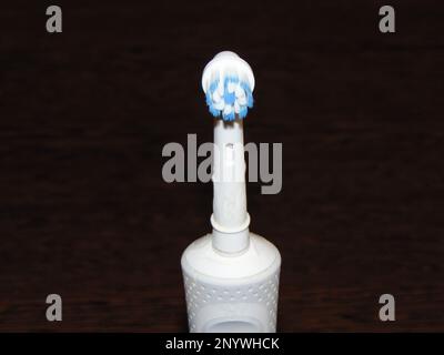 White electric toothbrush on a wooden background Stock Photo