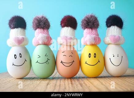 Happy eggs in hats laughing. Easter holiday concept with cute eggs with funny faces Stock Photo