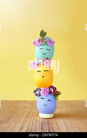 Funny Easter Eggs, hand drawn faces. Easter holiday concept with cute handmade eggs in floral wreath crowns Stock Photo