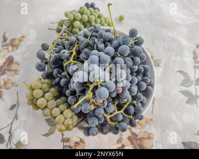 Black grapes and white grapes on a plate in Romania Stock Photo