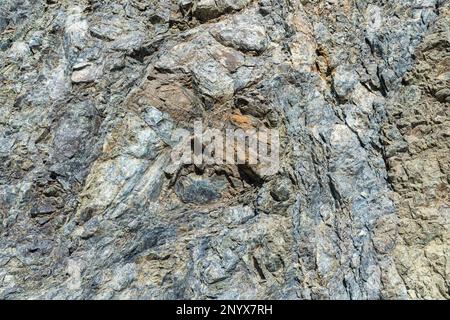 Fragment of grey rock in cracks. Close up of a mountain. Stock Photo