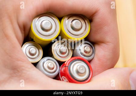 Man holding a bunch of rechargeable batteries, power and energy storage, old batteries recycling abstract concept, one person, ecology and safe batter Stock Photo