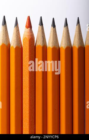 Orange Colored Pencil with Black Graphite Pencils and Orange Grip Stock Photo