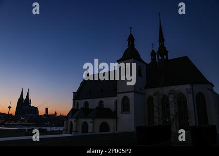 Cologne, Germany. 02nd Mar, 2023. The sky turns red and blue behind the Rhine panorama with the cathedral (l) and the church of St. Heribert (r) after sunset. Credit: Oliver Berg/dpa/Alamy Live News Stock Photo