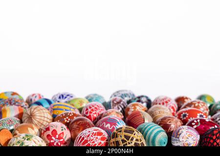 Lots of colorful Easter eggs laid out randomly on a solid white background. Stock Photo