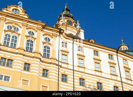 The sunny view of 18th century Melk Abbey and a tower with a clock in Melk town (Austria). Stock Photo