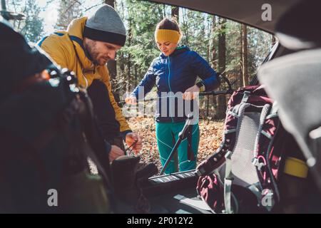 Young couple going for a hike, packing theri thinks in the car trunk Stock Photo