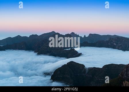 Highest hill of Madeira island above mist during sunset with colorful sky - view from Bica da Cana hill Stock Photo