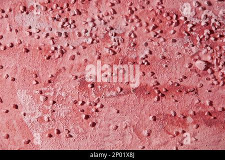 Dark red plaster background wallpaper with a smears and small pebbles. Abstract backgrounds and patterns for interior decor Stock Photo