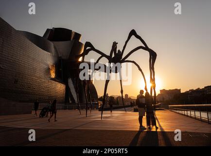 Bilbao, Spain - August 02, 2022: The Spider, sculpture of Louise Bourgeois titled Mamam next to the Guggenheim Museum at sunset Stock Photo